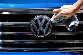 Ein Mitarbeiter reinigt das Logo eines SUV VW Touareg, das vor der Jahreshauptversammlung des deutschen Automobilherstellers Volkswagen am 3. Mai 2018 in Berlin ausgestellt ist.