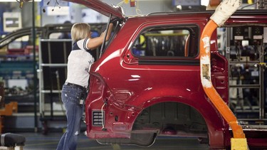 A worker on the production line at Chrysler's plant in Windsor, Ontario, works on one of the company's new minivans January 18, 2011 as the company celebrated the production launch of the new Dodge Grand Caravan and Chrysler Town and Country.