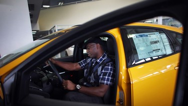 In this file photo, Anthony Gordon looks at a Ford Focus ST on the showroom floor at a Ford AutoNation car dealership in North Miami, Florida.