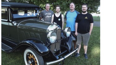 (Left to right) Kerry Rawson with his son David and Kenneth Rawson with his son Randy and the beautifully restored Auburn.