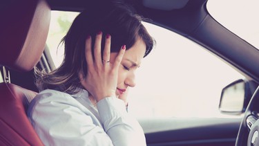 Stressed woman driver sitting inside her car