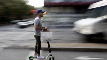 An unidentified Lime Scooter users ride the bike path along de Maisonneuve Street in Montreal, on Wednesday, August 21, 2019.