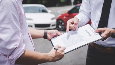 Insurance Agent examine Damaged Car and customer filing signature on Report Claim Form process after accident, Traffic Accident and insurance concept