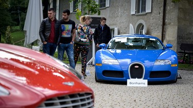 A picture taken on September 28, 2019 at the Bonmont Abbey in Cheserex, western Switzerland shows a 2010 Bugatti Veyron EB 16.4 Coupe model car (R) and a 2011 Aston Martin One-77 Coupe model car during an auction preview by sales house Bonhams of sport cars belonging to the son of the Equatorial Guinea's President.