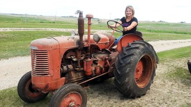 Deb Tait sits on her grandfather’s unrestored 1948 Case Model S tractor on the family homestead near Kipling, Saskatchewan.
