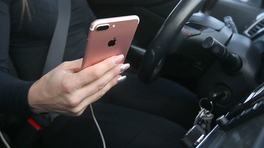 A driver checks her phone while behind the wheel in Calgary Saturday, January 12, 2019. Policesay theyve handed out fewer distracted driving tickets since penalties for the offence in Alberta were toughened a couple years ago.