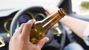 Man drinking beer while driving in his car