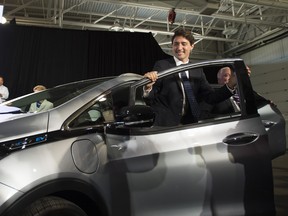 In this file photo, Prime Minister Justin Trudeau exits a Chevrolet Bolt electric car during the announcement that GM plans to hire up to 1000 engineers in Canada at the GM plant in Oshawa, ON on Friday, June 10, 2016.