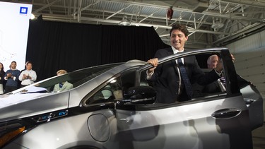 In this file photo, Prime Minister Justin Trudeau exits a Chevrolet Bolt electric car during the announcement that GM plans to hire up to 1000 engineers in Canada at the GM plant in Oshawa, ON on Friday, June 10, 2016.