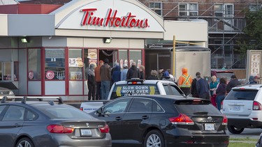 Customers line up at a Tim Hortons on Sunday, Sept. 8, 2019. The City of Fredericton will spend $40,000 to direct motorists around a busy Tim Hortons, in the latest move by a Canadian municipality to curb traffic headaches and other concerns caused by restaurant drive-thrus.