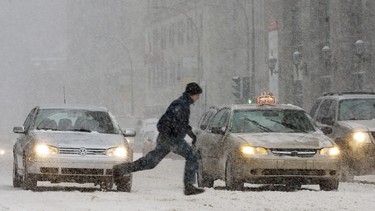 A pedestrian runs to cross a downtown Montreal street Monday, Jan 15, 2007, during the first snow storm to hit the city.
