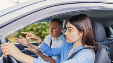 Woman taking driving lessons from instructor