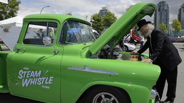 Bruce Stout with the Steam Whistle restored truck at Electrafest, a green mobility movement display of electric transportion options on Pacific Blvd at Carrall St. in Vancouver.