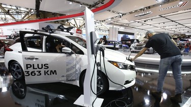 A showgoer checks out a Nissan Leaf during last year's Canadian International Auto Show in Toronto.