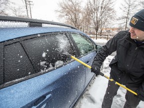 A man scrapes ice and snow