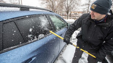 A man scrapes ice and snow