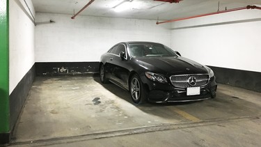 A Mercedes-Benz parked in a questionably courteous manner at a downtown Toronto parking garage.