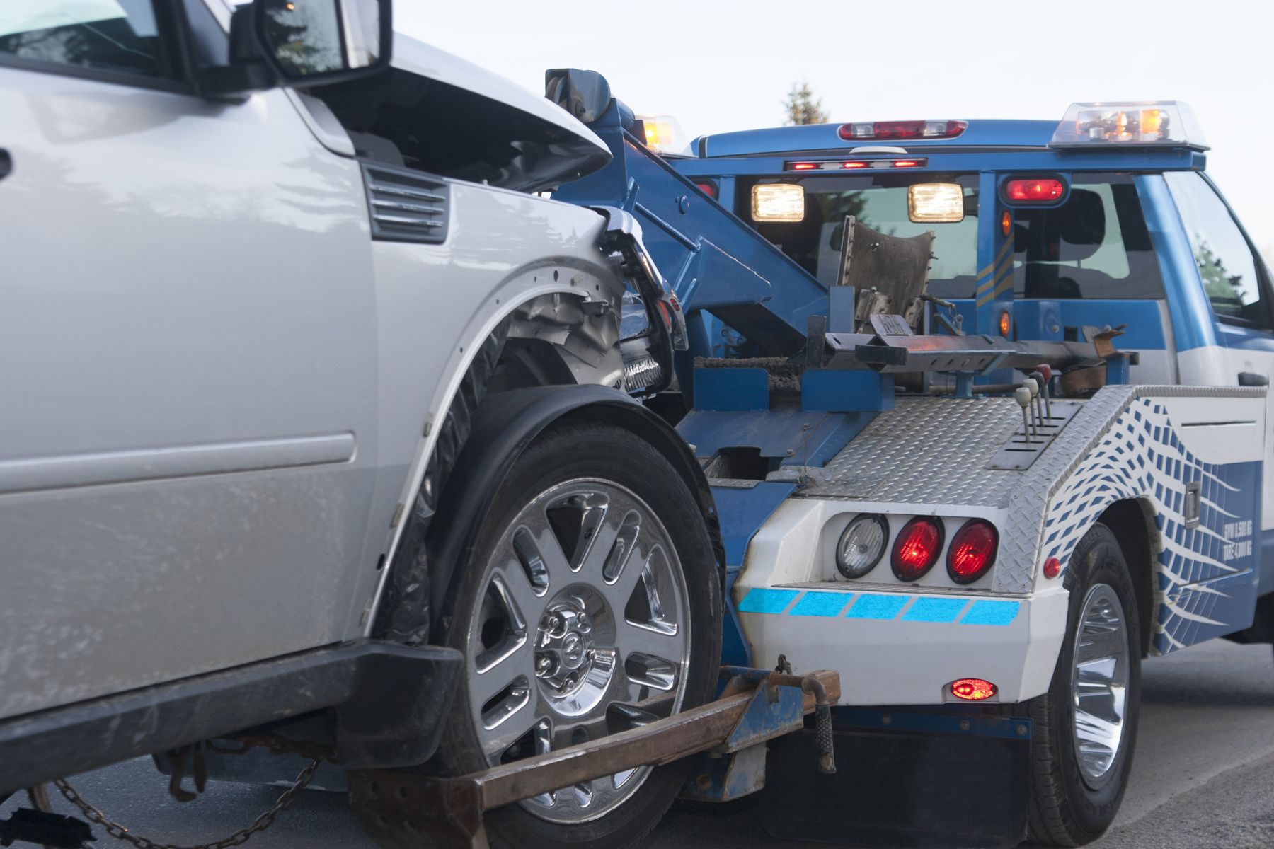 A damaged new vehicle on a tow truck