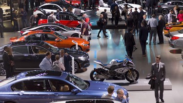 People walk through the BMW showroom Wednesday, March 28, 2018, at the New York Auto Show.