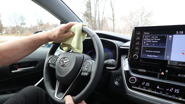 person disinfecting his steering wheel for covid-19