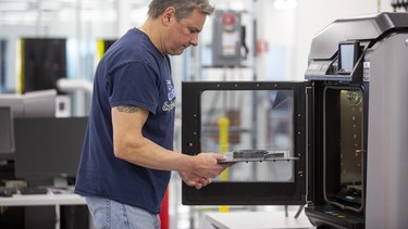 Dave Jacek, 3D printing technician, unloads 3D printed medical face shield parts at Ford’s Advanced Manufacturing Center.