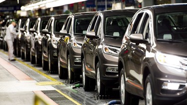 Workers inspect vehicles and work on the assembly line at Honda of Canada Mfg. Plant 2 in Alliston, Ont., on Monday, March 30, 2015.