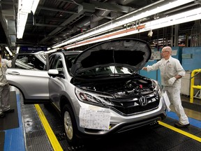 Workers inspect vehicles and work on the assembly line at Honda of Canada Mfg. Plant 2 in Alliston, Ont., on Monday, March 30, 2015.