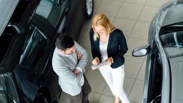Salesperson showing vehicle to potential customer