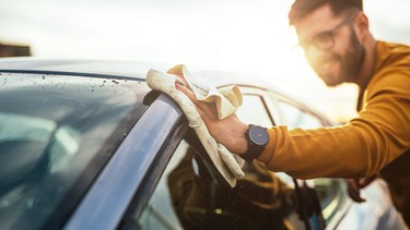 A man proudly washing his newly purchased car