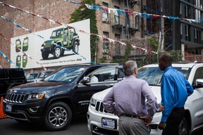 In this file photo, a salesman helps a customer shop for a Jeep at a car dealership in New York City