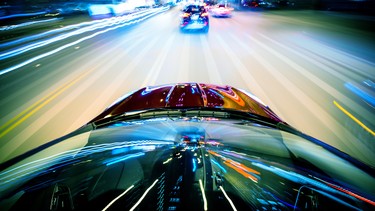 A car speeding at night, causing motion blur.