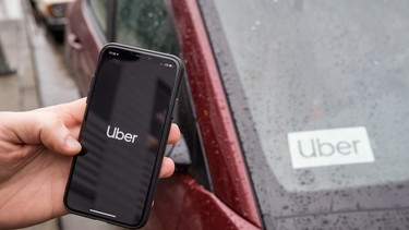 The Uber app is seen on an iPhone near a driver's vehicle after the company launched service, in Vancouver, Friday, Jan. 24, 2020.