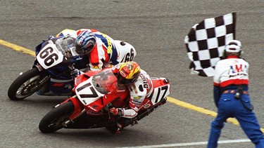 In this March 7, 1999, file photo, Miguel Duhamel (17) edges out Mat Mladin (66) as the pair crosses the finish line of the Daytona 200 motorcycle race in Daytona Beach, Florida.