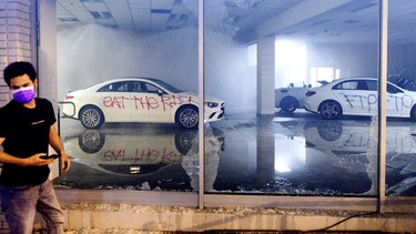 Vandalized cars sit in a Mercedes-Benz of Oakland showroom during in Oakland, Calif., on Saturday, May 30, 2020, during protests against the Monday death of George Floyd, a handcuffed black man in police custody in Minneapolis.