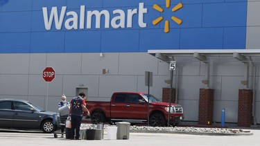 Workers sanitize items outside a Walmart that has been closed following the deaths of three people connected to the store after they were infected with the new coronavirus.