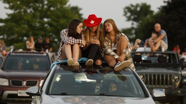Concert-goers sit atop their vehicle during a drive-in Dean Brody concert to celebrate Canada Day on July 1, 2020 in Markham, Canada.
