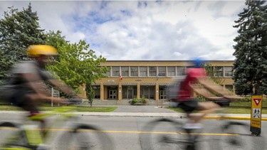 Cyclists ride past St-Monica's School on Terrebonne St. in Notre-Dame-de-Grâce. The borough intends to put a bike path on the street running in front of the school where school buses usually park.