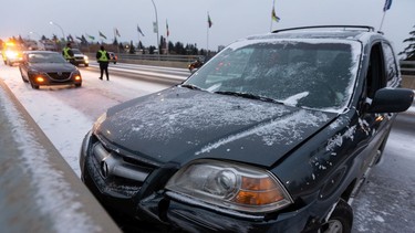 A crashed Acura SUV is seen on the 82 Avenue bridge west of 93 Street as snow falls in Edmonton, on Monday, Oct. 19, 2020. Multiple crashes occurred when snow made the bridge surface slick.