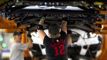 Assembly line workers at the General Motors Assembly plant in Oshawa work on cars on Friday December 16, 2011.