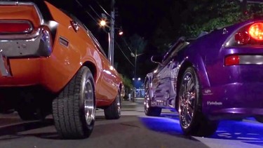 A still from "2 Fast 2 Furious" depicting a drag race between a Dodge Challenger and a Mitsubishi Eclipse