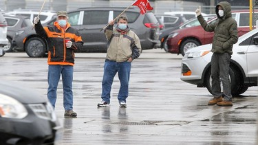 Unifor Local 444 members react to passing motorists while maintaining their presence at Windsor Assembly Plant's Walker Road shipping gate during a labour dispute involving the union and Motipark Sunday.