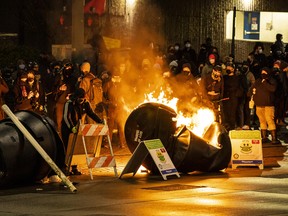 Demonstrators watch a barricade burn at an intersection in downtown Tacoma during an anti-police protest on January 24, 2021 in Tacoma, Washington.