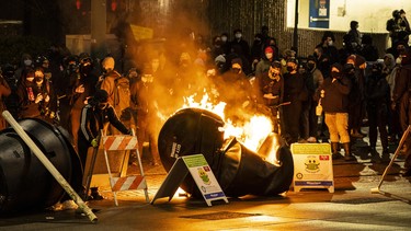 Demonstrators watch a barricade burn at an intersection in downtown Tacoma during an anti-police protest on January 24, 2021 in Tacoma, Washington.