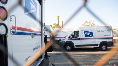 Postal trucks are parked at a United States Postal Service (USPS) post office location in Washington, DC, April 16, 2020.