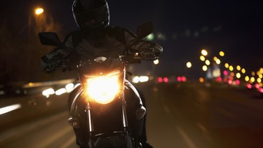 Young Man riding a motorcycle at night