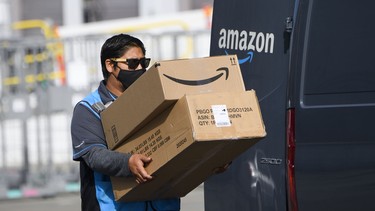 An Amazon.com Inc. delivery driver carries boxes into a van outside of a distribution facility on February 2, 2021 in Hawthorne, California.