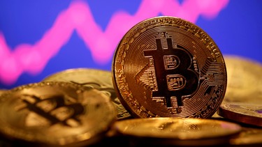 A representation of virtual currency Bitcoin is seen in front of a stock graph in this illustration taken January 8, 2021.