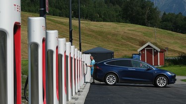 A driver prepares to charge his Tesla car at a Tesla Supercharger charging station on August 12, 2020 in Skei, Norway.