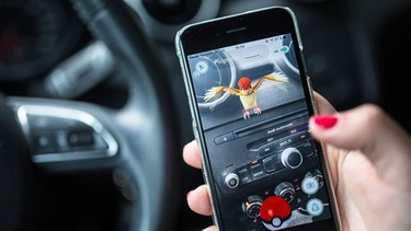 A woman plays the Pokemon Go mobile game on her smart phone in a car in Berlin on July 13, 2016.