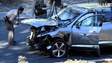 Los Angeles County Sheriff's Deputies inspect the vehicle of golfer Tiger Woods, who was rushed to hospital after suffering multiple injuries, after it was involved in a single-vehicle accident in Los Angeles, California, U.S. February 23, 2021.